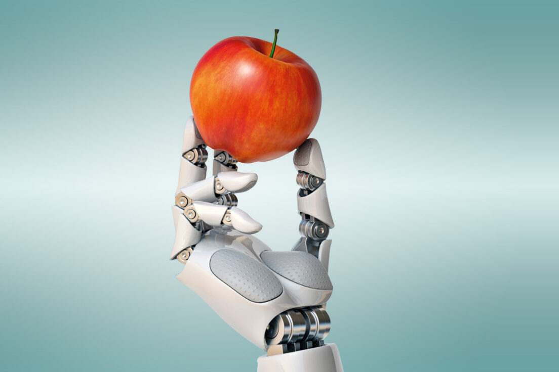 Robot hand holding a red apple.