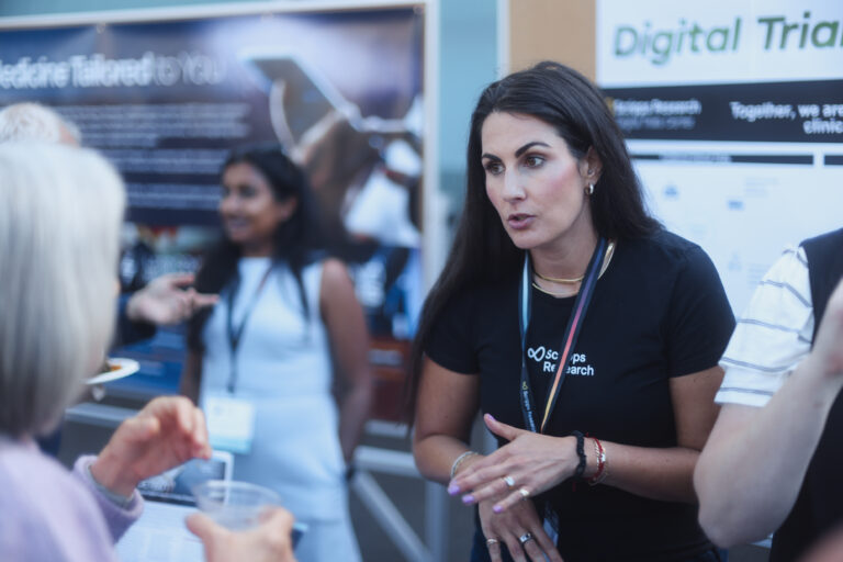 Woman presenting research in front of a poster board.