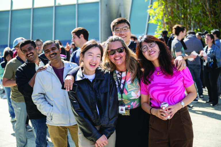 Diverse group of Scripps Research employees smiling together outdoors at a campus event