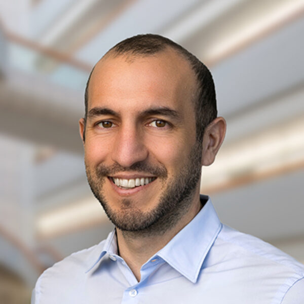 Professional headshot of Ali Torkamani, Scripps Research Translational Institute faculty member, with a bright indoor background.