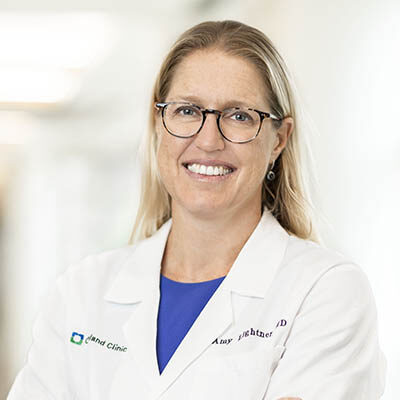 Professional headshot of Amy Lightner, MD, physician-scientist on the SRTI Executive Committee, wearing a white clinical coat.
