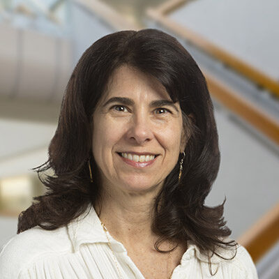 Professional headshot of Athena Philis-Tsimikas, Scripps Research Translational Institute faculty, with staircase background.