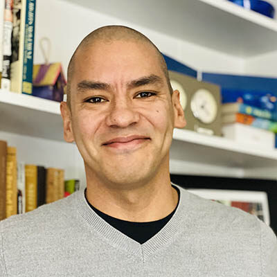 Professional headshot of Ed Ramos, Scripps Research Translational Institute staff member, in front of a bookshelf.