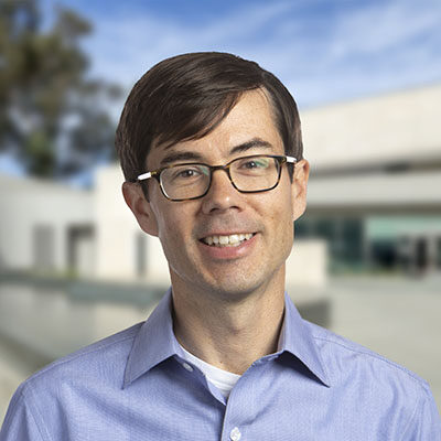 Professional headshot of Evan Muse, Scripps Research Translational Institute faculty, wearing glasses with a campus background.