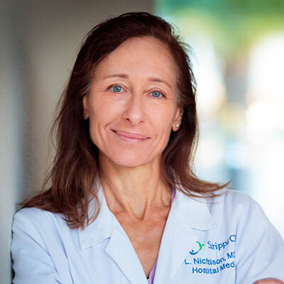 Professional headshot of Laura Nicholson, MD, Scripps Research physician-scientist, wearing a white clinical lab coat.