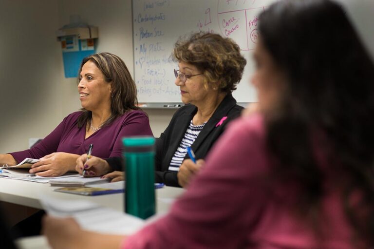 Women sitting at a desk during a workshop.