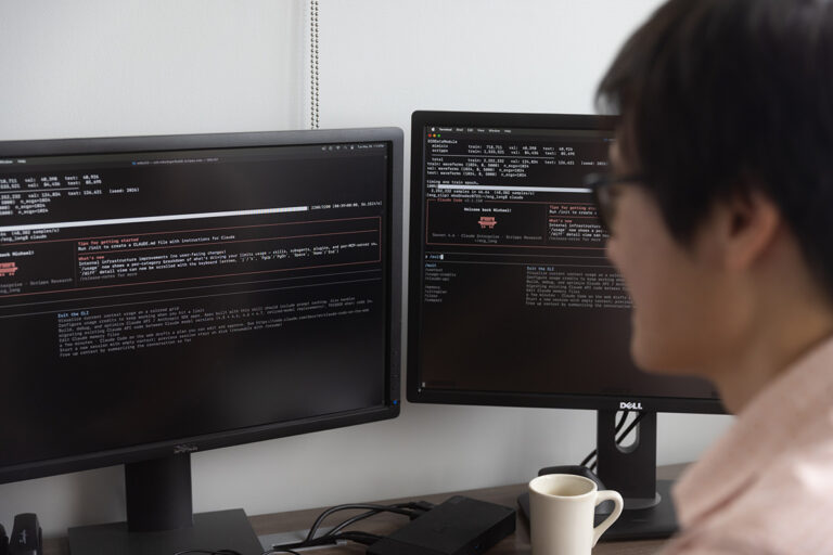 Computational scientist looking at code on a monitor.